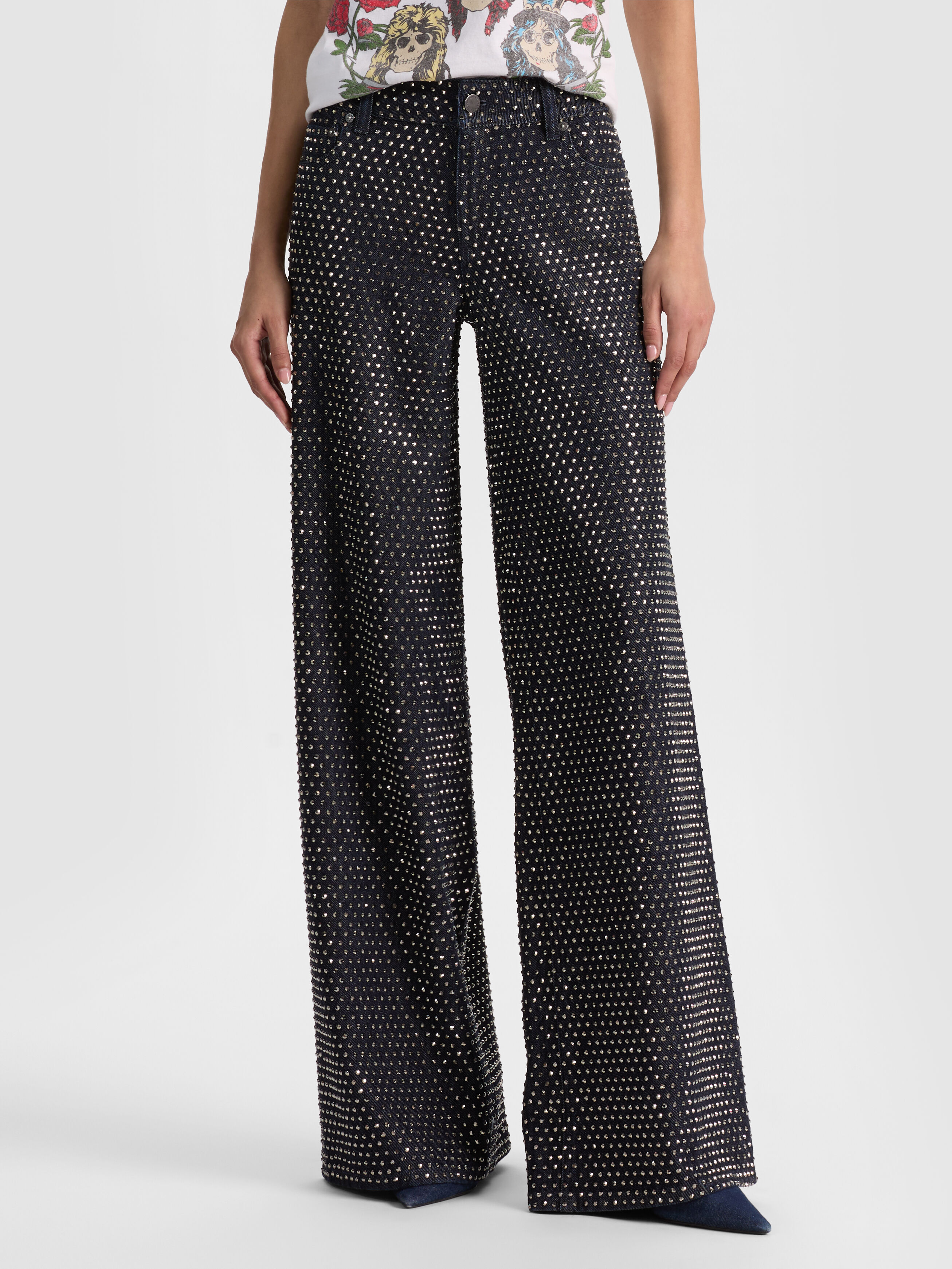 A woman wearing the ALICE + OLIVIA Amazing Embellished Jean in a luxurious dark-rinse wash, representing the dark-wash refinement denim trend for 2026.