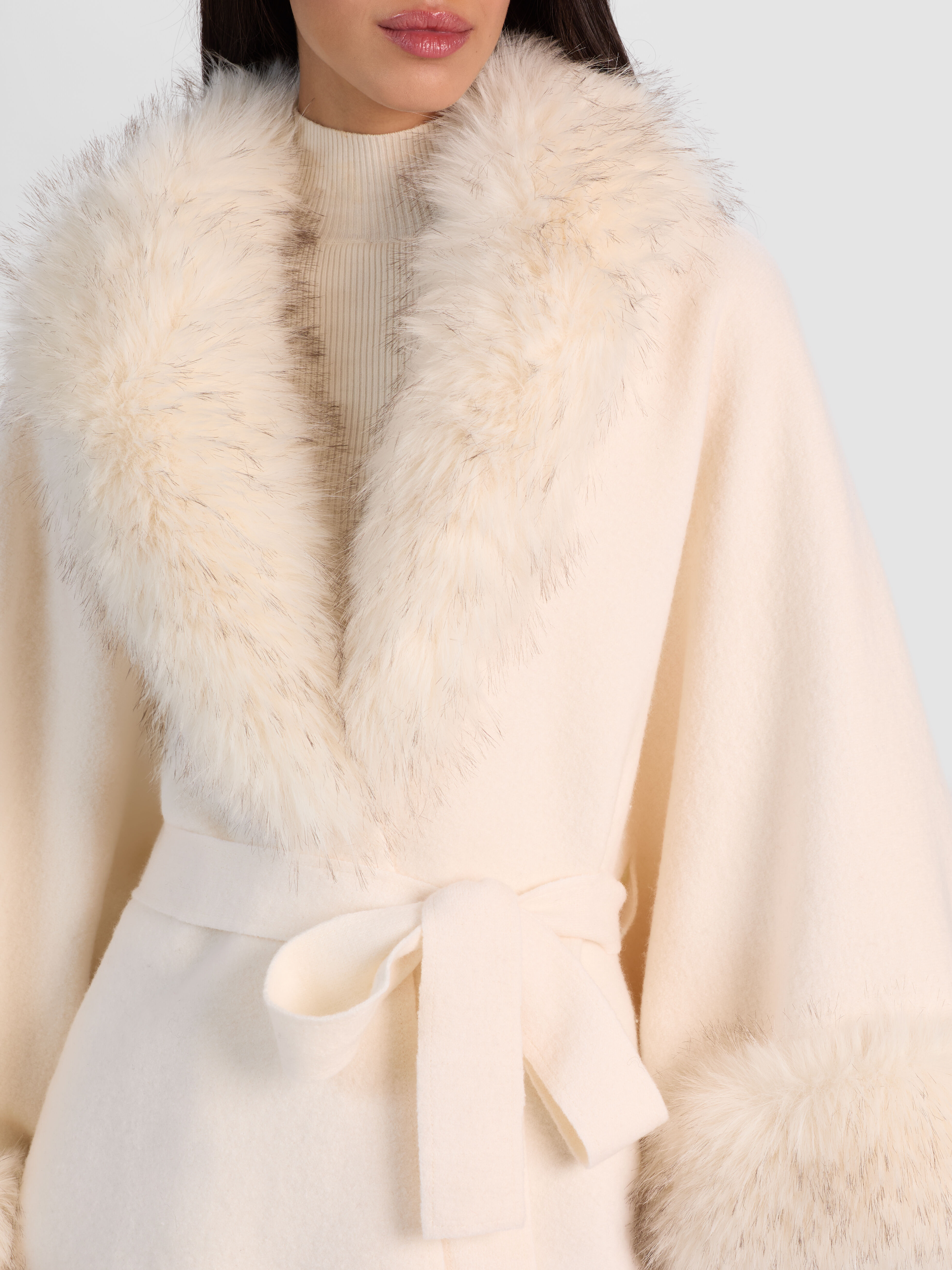 ALICE + OLIVIA Joanne Sweater Coat in ecru wool with detachable faux fur trim, worn by Anastasia Gerrans at NYFW 2026