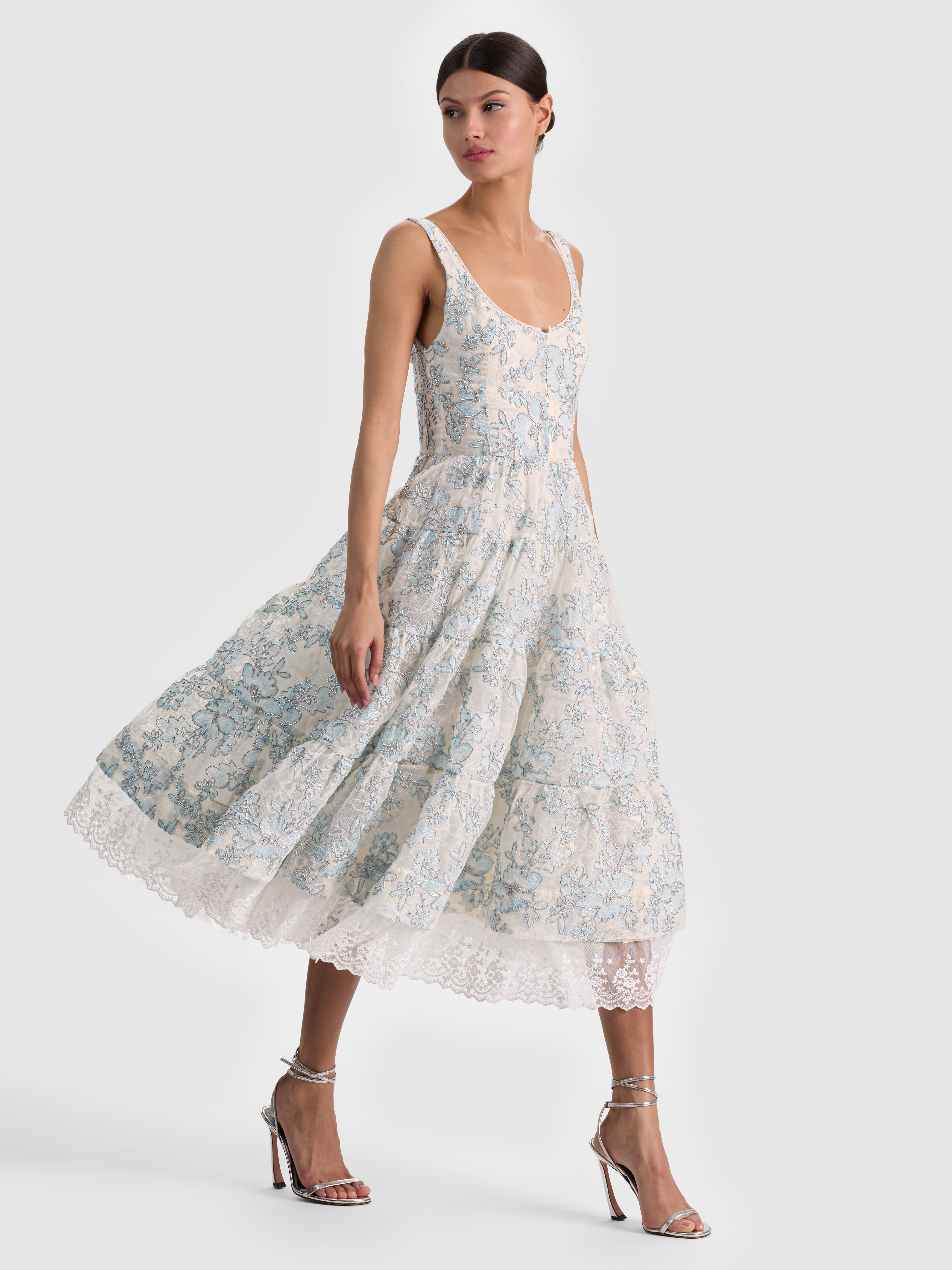 A model wearing a tea-length dress falling just above the ankle in a vintage-inspired, polished style perfect for a garden party or bridal shower